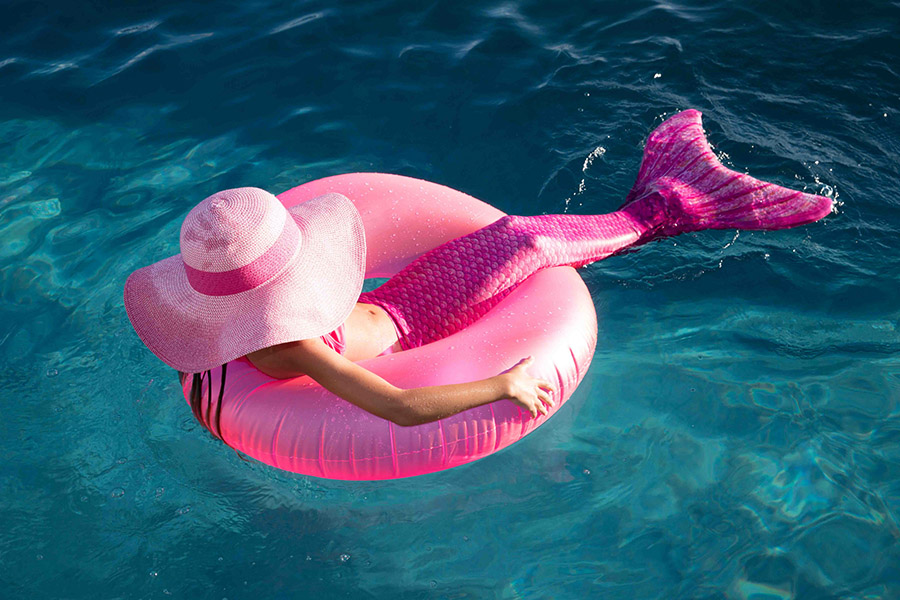 a mermaid sitting on a pool float to represent mermaid mania pool parties