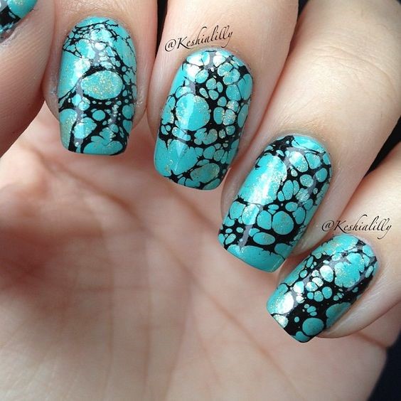 black and teal nails that resemble turquoise stones