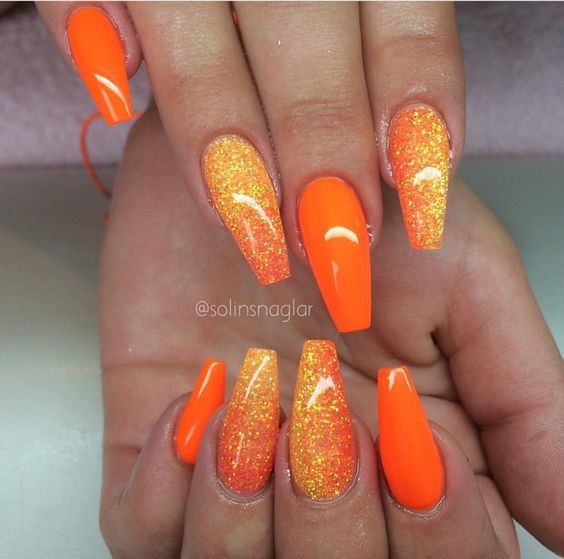 vivid orange nails with yellow glitter accents that match the tropical sunrise mermaid tail