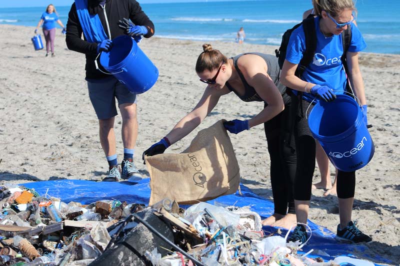 people cleaning up trash from the beach