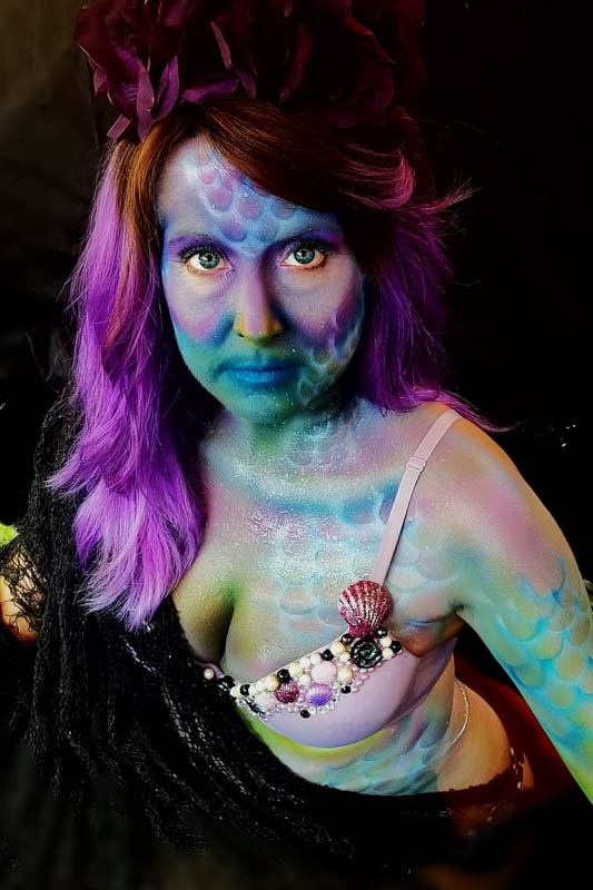 a girl sporting colorful mermaid body art for the costume contest