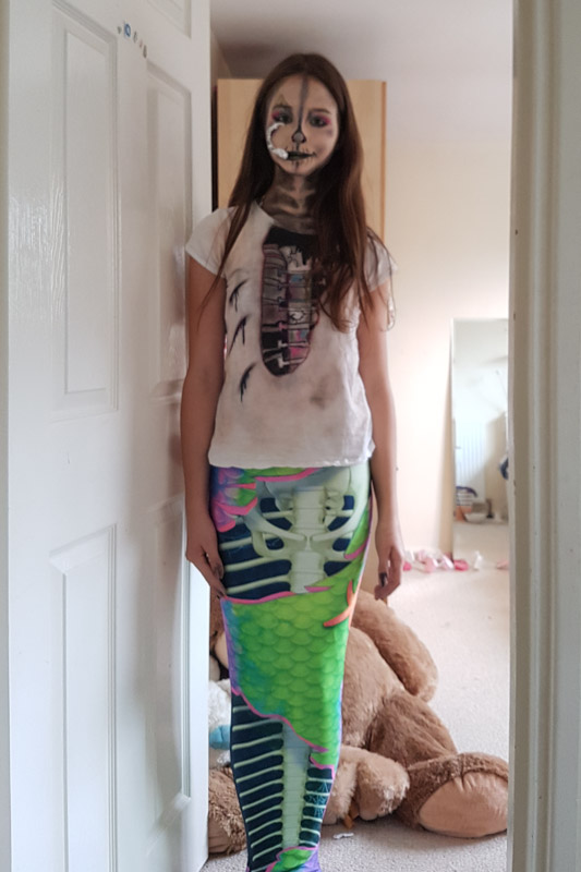 a girl dressed as a zombie mermaid with the Neon Skeletail mermaid tail for swimming