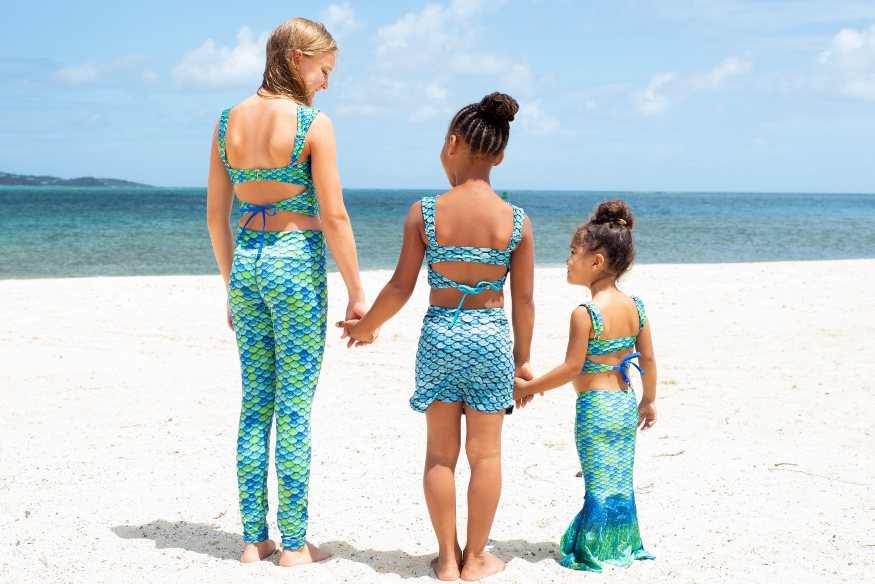 three girls in Fin Fun Mermaiden swimwear on a beach