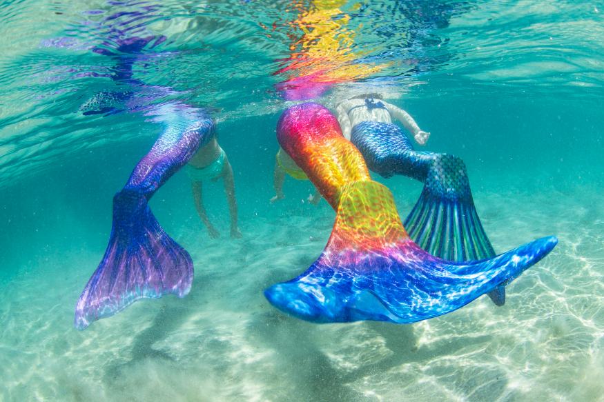 three girls swimming underwater in Fin Fun Limited Edition mermaid tails