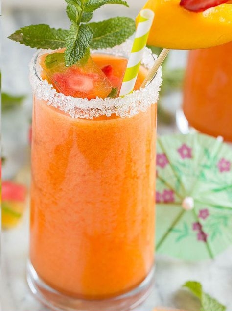 this fancy mermaid drink is an orange-pink drink in a sugar-rim glass