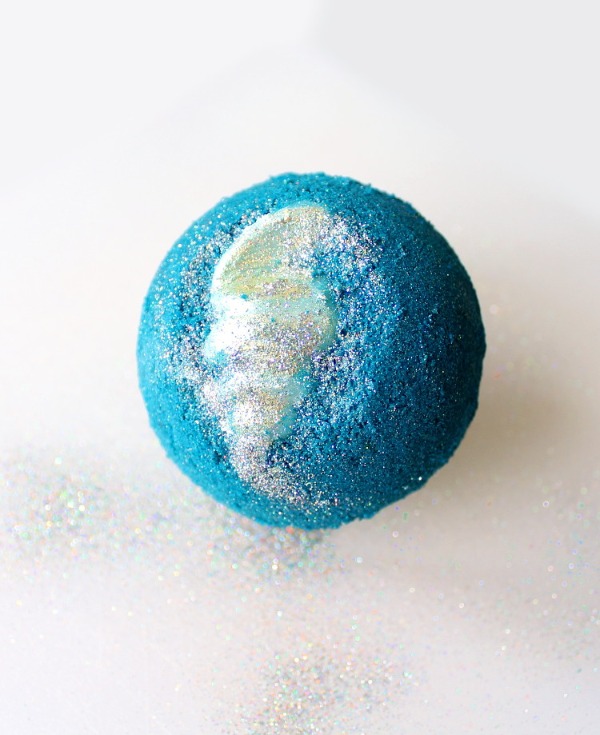 a blue bath bomb with a cocoa butter shell inside