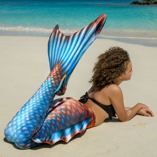 girl laying on the beach in the Bronzed Sapphire Atlantis tail