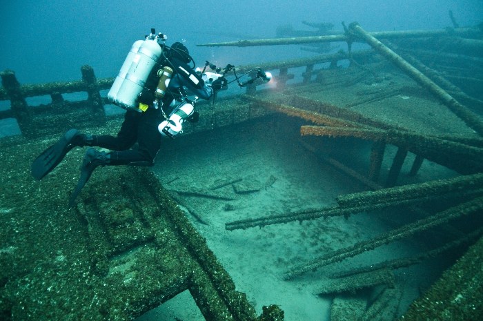 a scuba diver examining a shipwreck underwater