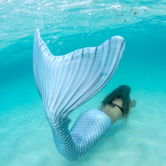 girl swimming underwater in the mermaid tail that matches April's birthstone, the Silver Lightning Limited Edition tail