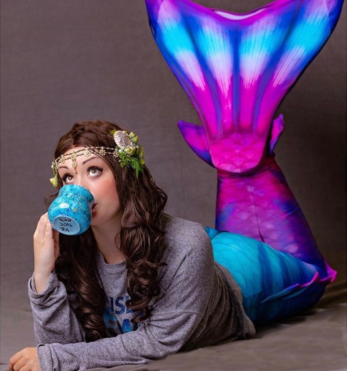 girl sipping from a mug while wearing a Fin Fun Atlantis mermaid tail