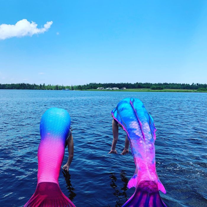 to mermaids diving into a lake
