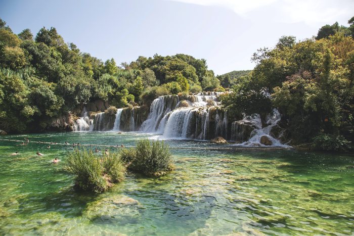 a waterfall surrounded by greenery