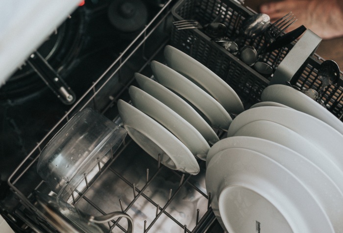 someone filling up a dishwasher