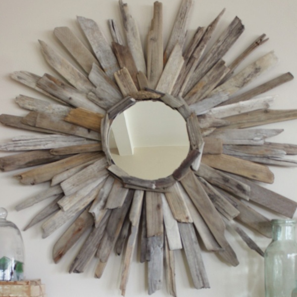 a sunburst mirror made with pieces of driftwood radiating from the center