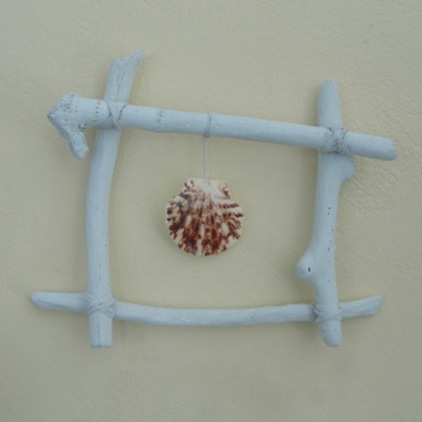 a simple driftwood frame, painted white, displays a single sea shell