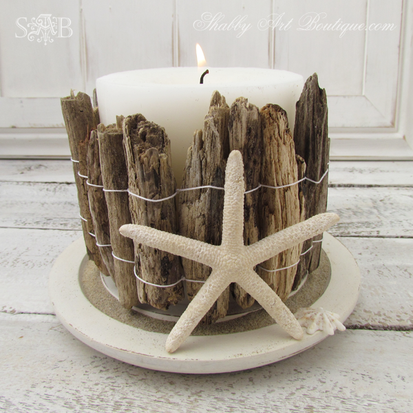 a white candle in a decorative DIY driftwood candle holder