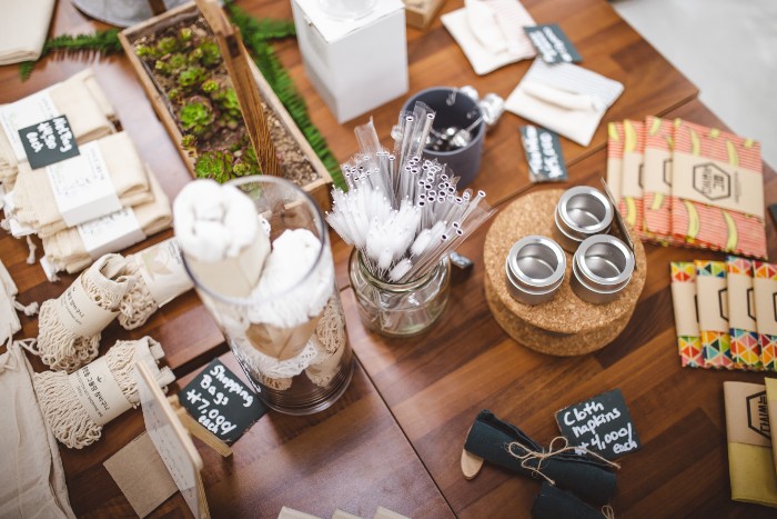 a table with a variety of reusable products, including straws, napkins, and shopping bags