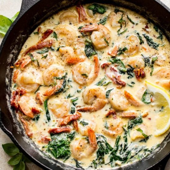 a cast iron skillet with creamy garlic butter Tuscan shrimp: the perfect mermaid dinner recipe for mers that love Italian food