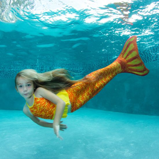 girl swimming underwater in the orange and yellow Tropical Sunrise mermaid tail