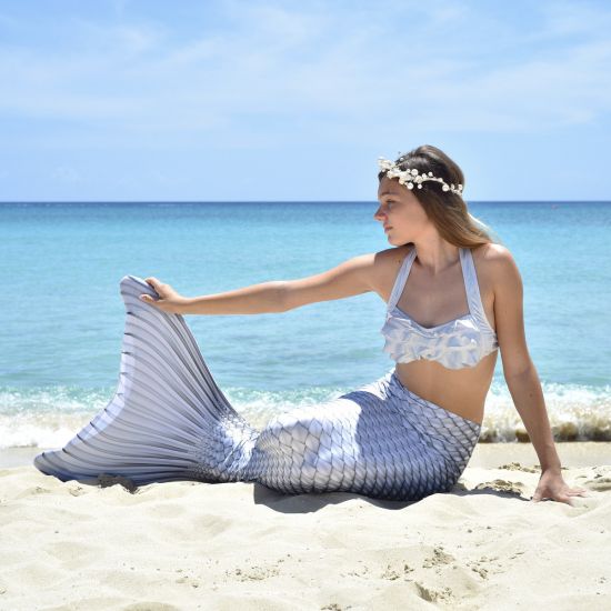 girl in a silver bikini and mermaid tail wearing a white headpiece