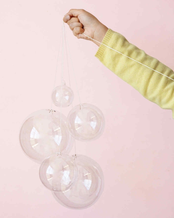 a single arm in the frame holds their DIY bubble chandelier