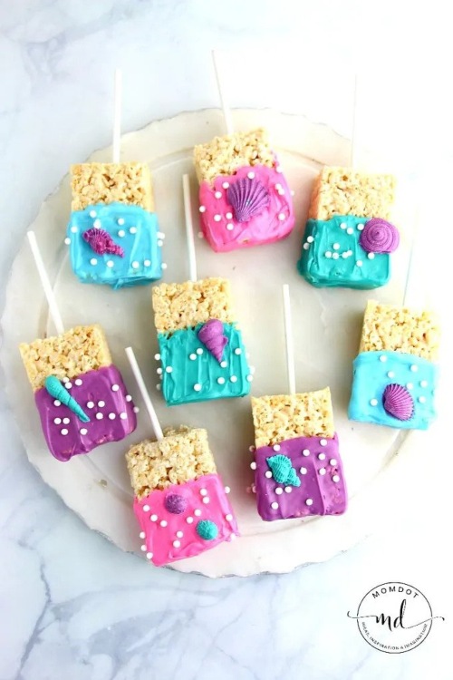 a plate of mermaid Rice Krispies treats decorated with pearl sprinkles and shells