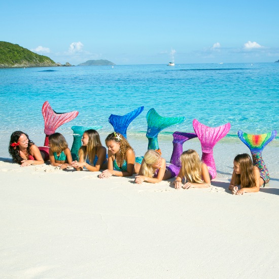 The original Mermaidens tails on mermaids laying on the beach