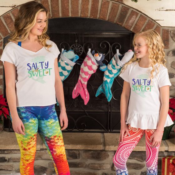 Two girls stand in front of mermaid stockings.