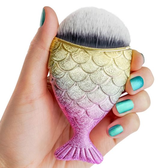 A hand with teal nail polish holds a gold and pink mermaid makeup brush.